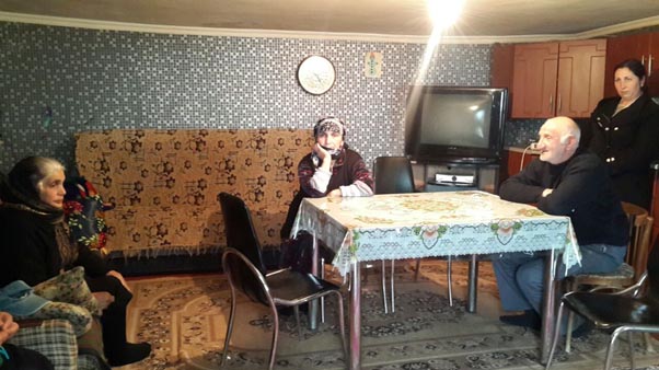 Ruslan’s mother, father, cousin and aunt sitting in the kitchen.